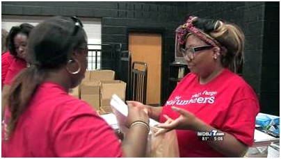 Volunteers filling 1,700 bags of faculty supplies lot of children that require